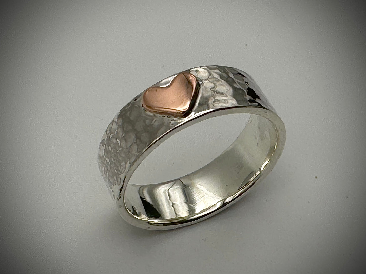 Handmade copper heart on silver hammered band